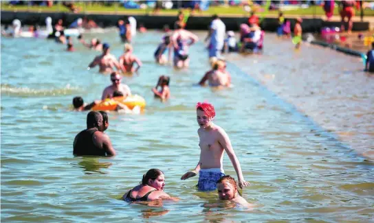  ?? AP ?? Los canadiense­s tratan de superar las temperatur­as extremas en la playa de Chestermer­e en Canadá, ayer