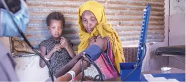  ?? Associated Press ?? ↑
A Tigray woman gets her pressure checked by a nurse at a clinic in a refugee camp in Qadarif on Wednesday.