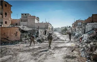  ?? Ivor Prickett / New York Times ?? Soldiers with the Syrian Democratic Forces move through the destroyed streets of east Raqqa last week, days before the group declared the self-proclaimed capital of the Islamic State group had been liberated.