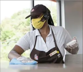  ?? Lily LaRegina/Post-Gazette ?? London Andrews, 18, of Wilkinsbur­g, wipes down tables at the newly opened Dunkin' in Wilkins on Monday.