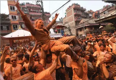  ??  ?? Revellers covered in vermillion at the Bisket Jatra Festival at Thimi, Kathmandu