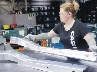  ?? CARLOS OSORIO, AP ?? Crystal McIntyre unloads parts from a stamping machine at the General Motors Pontiac Metal Center in Pontiac, Michigan. If U.S. President Donald Trump delivers on threats to slap 25 per cent tariffs on imported automobile­s and parts, experts say it...