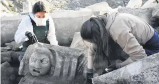  ??  ?? An archaeolog­ist works on a face mask in the ancient city of Stratonike­ia, Nov. 24, 2020.