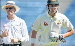  ??  ?? Onfield umpire Nigel Llong of England (L) looks on as Australia's Matthew Renshaw holds his stomach while running back to the pavilion.