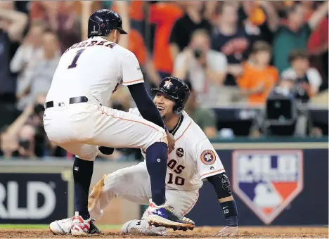 ?? RONALD MARTINEZ/GETTY IMAGES ?? The Astros’ Carlos Correa and Yuli Gurriel celebrate after they scored on an Alex Bregman double against New York Yankees reliever David Robertson in the eighth inning Friday as Houston forced Game 7 in the ALCS with a 7-1 win at Minute Maid Park.