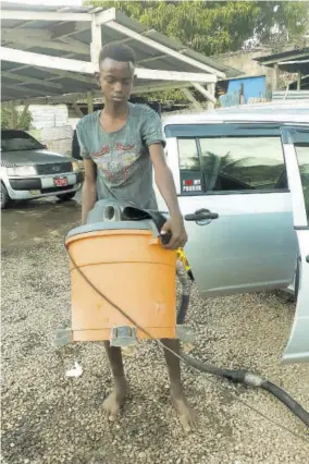  ?? (Photos: HG Helps) ?? Tina’s Car Wash employee Najay Morris gets down to hard work.