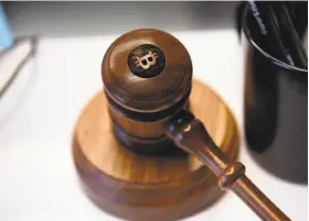  ?? Michael Short / Bloomberg ?? A bitcoin gavel appears on a desk at the Coinbase office in San Francisco. Coinbase wants to use digital money to reinvent finance.