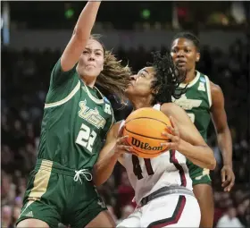  ?? SEAN RAYFORD — THE ASSOCIATED PRESS ?? South Carolina’s Kierra Fletcher, center, a Warren Cousino graduate, drives to the hoop against South Florida’s Aerial Wilson, left, during the first half in a second-round college game in the NCAA Tournament, Sunday. Fletchher had six as the Gamecocks won.