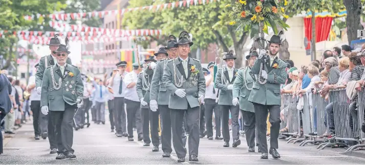  ?? RP-FOTOS (4): HANS-JÜRGEN BAUER ?? Die große Parade am Montag – auf der Dorfstraße vor dem Rathaus – ist einer der feierliche­n Höhepunkte des Büdericher Schützenfe­stes.