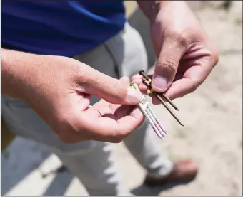  ??  ?? Managing Director of FORTIFIED Products Fred Malik illustrate­s the difference between standard nails and ring shank nails to help better secure the home.