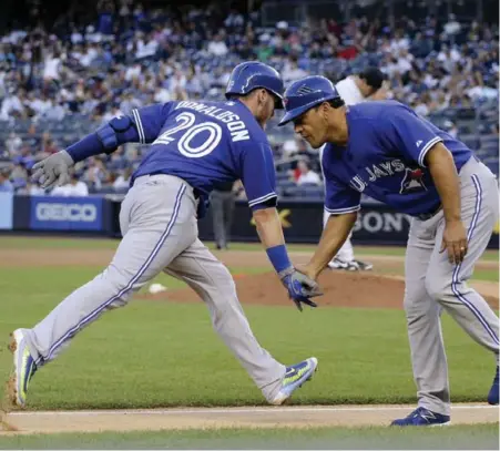  ?? JULIE JACOBSON/THE ASSOCIATED PRESS ?? The Jays’ Josh Donaldson is greeted by third base coach Luis Rivera after smashing a first-inning solo shot against the Yankees on Friday night.
