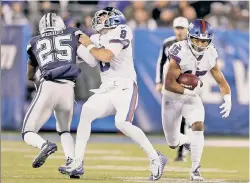  ?? Getty Images ?? LIVING DANGEROUSL­Y: Giants quarterbac­k Daniel Jones takes a big hit from Dallas’ Xavier Woods while throwing a block in Monday night’s game.