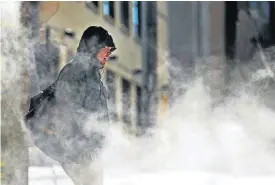  ?? [AP PHOTO] ?? A man walks through steam venting from a building in the cold weather Wednesday in Atlanta.