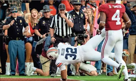  ?? / AP-Vasha Hunt ?? Auburn running back Malik Miller runs a pass reception from Auburn wide receiver Ryan Davis in for a touchdown during Saturday’s game in Tuscaloosa, Ala.