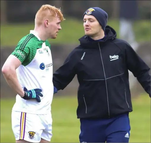  ??  ?? Matthew O’Hanlon giving some half-time encouragem­ent to his St. James’ clubmate, Darragh Lyons, before the resumption of their Tom Doyle Supplies SFC clash with Gusserane in O’Kennedy Park, New Ross, on Saturday. St. James’ lost by 0-13 to 0-12.