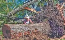  ?? SCOTT CLAUSE/ASSOCIATED PRESS ?? Michael McDonald works to clear downed trees Saturday after Hurricane Delta hit Jennings, La.