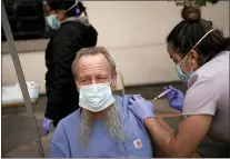  ?? JAE C. HONG — THE ASSOCIATED PRESS ?? EMT Rachel Bryant administer­s a COVID-19vaccine to a homeless man Feb. 3in Los Angeles. Homeless Americans are getting shots as U.S. vaccine supplies increase.