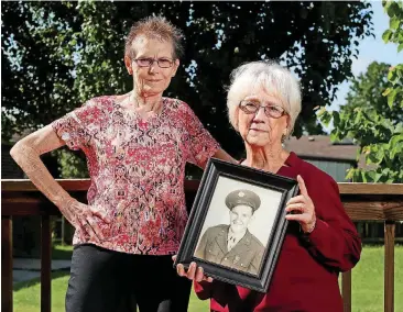  ?? [PHOTOS BY MATT BARNARD, TULSA WORLD] ?? Nathlia Brooks, left, and Norma Schneider show a photo Thursday in Broken Arrow, of their late uncle, Gene Sappington. Sappington was an MIA soldier whose remains went unidentifi­ed until modern DNA testing.