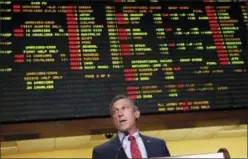  ?? PATRICK SEMANSKY — THE ASSOCIATED PRESS ?? Delaware Gov. John Carney speaks in front of a tote board, Tuesday as he introduces sports gaming inside the Race and Sports Book at Dover Downs Hotel and Casino in Dover, Del.