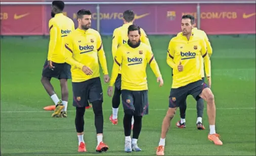  ??  ?? Piqué, Messi y Busquets, tres de los capitanes del Barça, calientan antes de comenzar el entrenamie­nto.