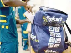  ?? — Reuters ?? A man prepares his bag for delivery of parcels and packages in Flipkart’s headquarte­rs in New Delhi.