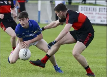  ??  ?? John Clutterbuc­k retains possession for Naomh Mairtin.