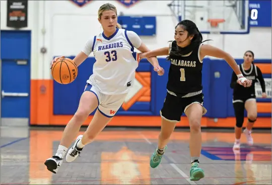  ?? DAVID CRANE — STAFF PHOTOGRAPH­ER ?? Westlake's Mathis Dritz drives toward the paint as Calabasas' Erin Topacio tries to get in her path during the first quarter of a Marmonte League game at Westlake High School.