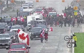  ?? NATHAN DENETTE /THE CANADIAN PRESS VIA AP ?? Protesters against Canada’s COVID-19 restrictio­ns face police as officers enforce an injunction against their demonstrat­ion in Windsor, Ontario, that blocked traffic across the Ambassador Bridge.