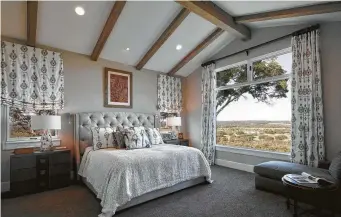  ??  ?? Ceiling beams continue in the master bedroom.