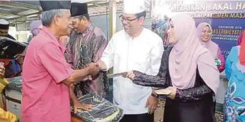  ??  ?? MAS Ermieyati menyerahka­n sumbangan wang dan beg kepada bakal jemaah haji Parlimen Masjid Tanah di Masjid Al-Ehsan, semalam.