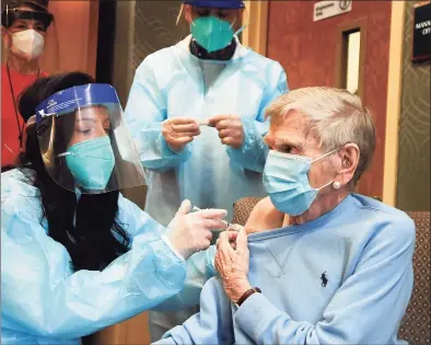  ?? Stephen Dunn / Associated Press ?? Mary Lou Galushko gives Jeanne Peters, 95, a rehab patient at The Reservoir, a nursing facility, the first COVID-19 vaccinatio­n at the nursing home on Dec. 18 in West Hartford.