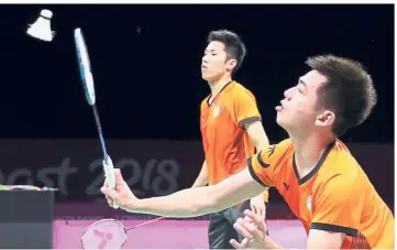  ??  ?? Quick action: Tan Wee Kiong (right) returning a shot as Goh V Shem looks on during the men’s doubles semi-final against England’s Marcus Ellis- Chris Langridge yesterday.