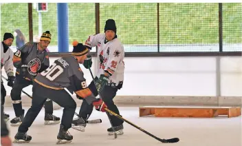  ?? FOTO: NORBERT PRÜMEN ?? Hier messen sich die Fischbach Flames gegen die Boels Bulls beim Pond-Hockey-Turnier in Grefrath. Der Puck muss in einer der beiden Öffnungen des Holzkasten.