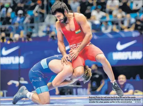  ?? HT PHOTO ?? ■ Bajrang Punia (in red) was tied 9-9 at the end of the semis against Daulet Niyazbekov but the bout was awarded to the local wrestler for a four pointer earlier in the second period.