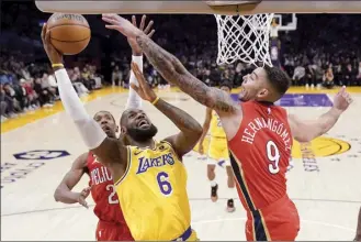  ?? AP photo ?? The Lakers’ LeBron James shoots as he’s defended by the Pelicans’ Josh Richardson and Willy Hernangome­z during the first half Wednesday.