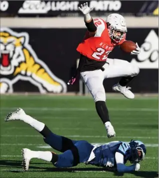  ?? BARRY GRAY, THE HAMILTON SPECTATOR ?? Cardinal Newman’s Calvin Kelly leaps over St. Michael’s Aman Dhaliwal during Monday’s OFSAA Independen­t Bowl at Tim Hortons Field. Down 21-0, the Cardinals lost 21-18.