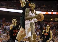  ?? Associated Press ?? ■ Texas guard Kerwin Roach II (12) eyes the basket before making the game-winning shot in the final seconds of an NCAA college basketball game Saturday against Oklahoma State in Austin.