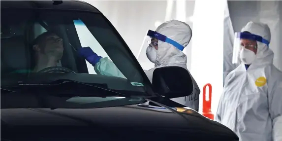  ?? HERALD FILE ?? A LOOK BACK: A patient is tested for the coronaviru­s at a drive-thru site at Gillette Stadium on April 5, 2020.