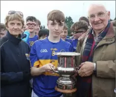  ??  ?? Ben Power, the St. Mary’s (Rosslare) captain, receives the trophy from Angela McCormack (Coiste na nOg Vice-Chairperso­n) and Brendan Furlong (People Newspapers).