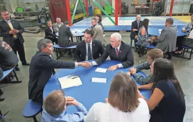  ?? PHOTOS BY MICHAEL SEARS/MILWAUKEE JOURNAL SENTINEL ?? Vice President Mike Pence (right) shakes hands with Bill Berrien of Whitefish Bay. Berrien owns a manufactur­ing company in New Berlin that employs 75 people. He along with his wife, Betsie, sons Joe, 10, and Will, 13, and daughter Grace, 17, met with the vice president on the administra­tion’s tax plan. Gov. Scott Walker (between Pence and Berrien) was also in on all the listening sessions. Pence and Walker toured Weldall Manufactur­ing Inc. in Waukesha and talked about the tax plan to employees. For more photos and a video, see jsonline.com/news.