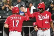  ?? ?? Kyle Farmer is greeted by Aristides Aquino after scoring the Reds’ lone run Wednesday in the ninth inning of a 6-1 loss in Chicago. The Reds are playing out the string after being eliminated from playoff contention.