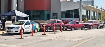  ??  ?? Fila de autos en el estacionam­iento del Centro de Convencion­es
