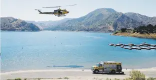  ?? ap foto/ringo h.w. chiu ?? Miembros de la policía del condado de Ventura realizaban su búsqueda por aire, agua y tierra en el lago Piru.