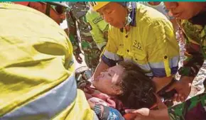  ??  ?? Rescue workers helping a woman yesterday, who survived after being trapped in rubble since Sunday’s earthquake.