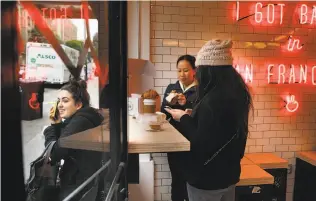  ??  ?? Far left: Allee Cakmis (left) waits for a ride as sisters Jen Lee and Anna Lee (right) sample the wares at Mr. Holmes Bakehouse on Larkin Street.