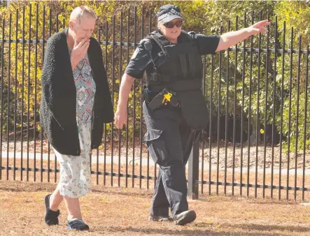  ?? Picture: EVAN MORGAN ?? CONCERN: A Garbutt resident with a police officer during yesterday’s lockdown.