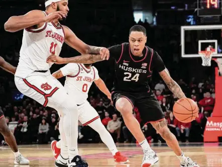  ?? Bebeto Matthews/Associated Press ?? UConn’s Jordan Hawkins, right, drives to the basket against St. John’s center Joel Soriano on Saturday.