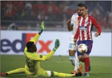  ?? PHOTO/FRANCOIS MORI ?? Atletico’s Antoine Griezmann (right) scores 2-0 passing Marseille’s goalkeeper Steve Mandanda (left) and Marseille’s Jordan Amavi (rear) during the Europa League Final soccer match between Marseille and Atletico Madrid at the Stade de Lyon in Decines,...