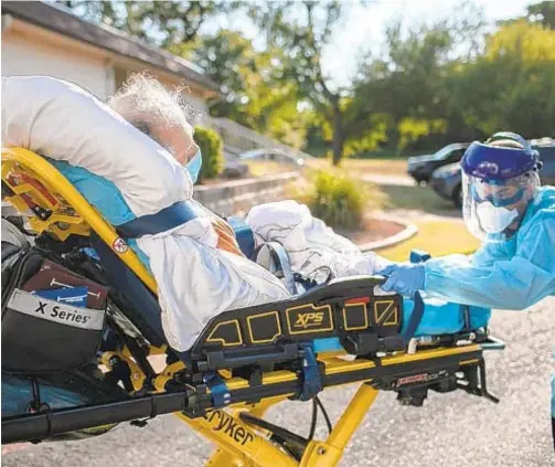  ?? JOHN MOORE/GETTY ?? A medic loads a patient with COVID-19 symptoms into an ambulance Aug. 5 in Austin, Texas.