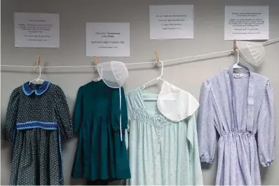  ?? The Associated Press ?? Dresses donated by sexual assault survivors from Amish and other plain-dressing religious groups hang on a clotheslin­e beneath a descriptio­n of each survivors’ age and church affiliatio­n on April 29 in Leola, Pa. The exhibit’s purpose was to show that sexual assault is a reality among children and adults in such groups. Similar exhibits held nationwide aim to shatter the myth that abuse is caused by a victim’s clothing choice.